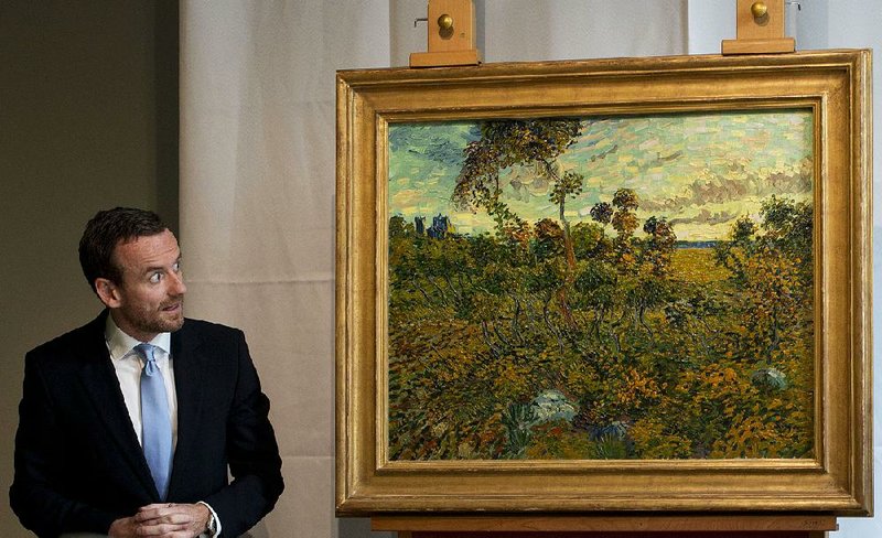 CAPTION CORRECTION, CORRECTS SPELLING OF SURNAME TO REFLECT AP STYLE - Van Gogh Museum director Axel Rueger, left, looks at "Sunset at Montmajour" after unveiling the painting by Dutch painter Voncent van Gogh during a press conference at the museum in Amsterdam, Netherlands, Monday Sept. 9, 2013. The museum has identified the long-lost painting which was painted by the Dutch mater in 1888, the discovery is the first full size canvas that has been found since 1928 and will be on display from Sept. 24. (AP Photo/Peter Dejong)