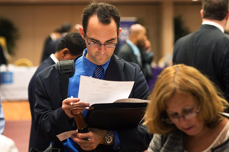 Job seeker Michael Grosberg reviews his resume during a job fair last month in New York. Advertised job openings fell 180,000 in July to 3.7 million, the Labor Department said Tuesday. 