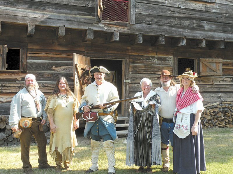 Members of the Early Arkansaw Re-enactors Association will present the Cadronburg Gala from 9 a.m. to 5 p.m. Sept. 14 at Cadron Settlement Park. Shown here in front of the Cadron blockhouse during the group’s recent annual picnic at the park are, from the left, James Thompson, Teresa Lafferty and Ed Williams, all of Little Rock; Ree Walker of Damascus; and Larry and Rita “Scooter” Layne of Sheridan. Williams will participate in the re-enactment of a Revolutionary War battle; Walker will demonstrate weaving techniques, including overshot weaving that she used to make the table runner she is holding; and Scooter Layne will present a children’s tea at Saturday’s event. 
