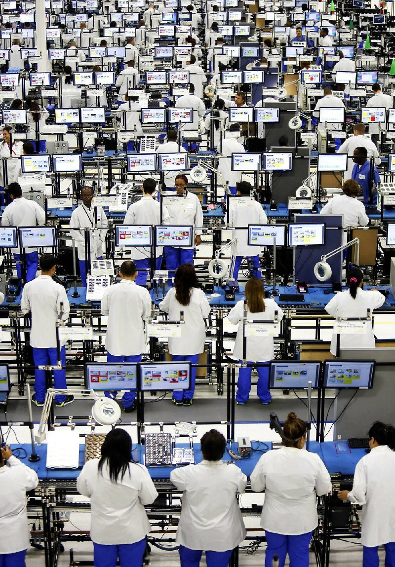 Employees assemble Motorola Solutions Inc. Moto X smartphones at the Flextronics International Ltd. factory in Fort Worth on Tuesday. More than 2,000 Flextronics International Ltd. employees have been contracted to manufacture the smartphone. 