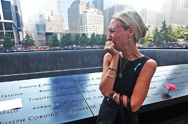 Carrie Bergonia of Pennsylvania finds the name of her fiance, firefighter Joseph Ogren, at the 9/11 Memorial in New York City on Wednesday. Ogren responded with his unit after the World Trade Center was attacked. His body was never found. 