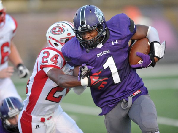 Fayetteville High School's Dre Greenlaw tries to push past Jefferson City's Rahem Moorman during the first half of Friday nights game at Harmon Field in Fayetteville.