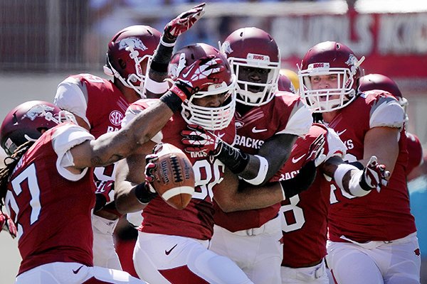 Arkansas teammates congratulate defensive end Trey Flowers after he intercepted a pass in the first quarter of the game against Southern Miss on Saturday September 14, 2013 at Razorbacks Stadium in Fayetteville. 