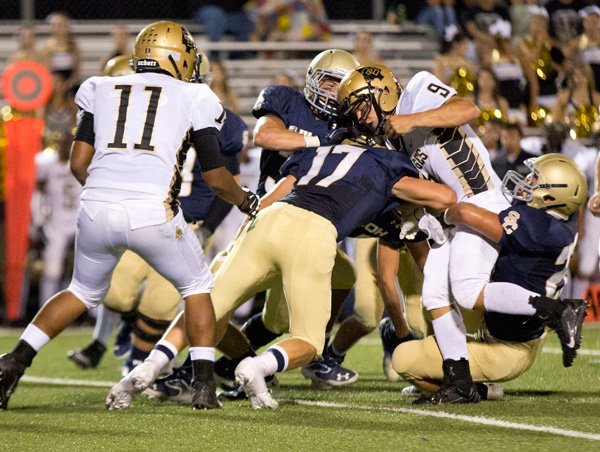 Jarred Moore (17) along with other Saint defenders bring down Broken Bow's quaterback Jake Callaham (9).  The defense held Broken Bow scorless during first half of the game  at Champion Stadium in Springdale, AR, on September 13, 2013.