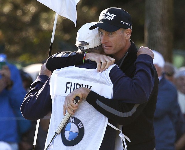 Jim Furyk (right) hugs his caddie, Mike “Fluff” Cowan, after shooting a 12-under-par 59 Friday, tying the PGA single-round record for lowest score, during the second round of the BMW Championship at Conway Farms Golf Club in Lake Forest, Ill.