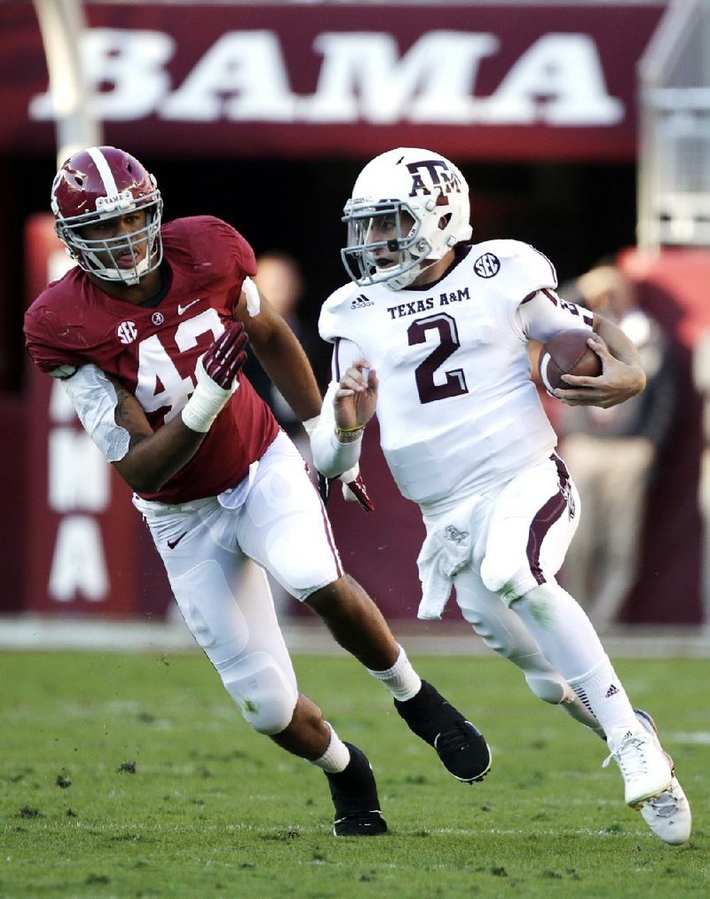 Texas A&M quarterback Johnny Manziel (right) outruns Alabama linebacker Adrian Hubbard during the first half of last season’s victory over the Crimson Tide in Tuscaloosa, Ala. Crimson Tide Coach Nick Saban has said he doesn’t want his defensive backs watching Manziel when he’s flushed from the pocket during today’s game because too many things can happen, most of them bad. 