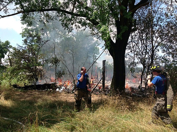 Firefighters at the scene of a July 24th fire at 11888 Malone Road.  The abandoned house was destroyed, but other firefighters nearby were able to extinguish a fire to an abandoned house at 12220 Hendrix Road.
