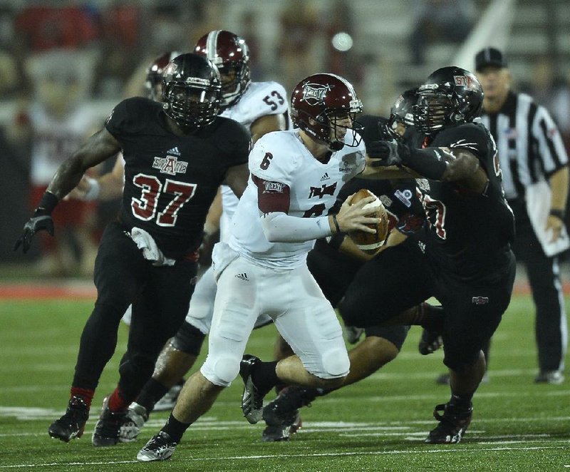 Troy quarterback Corey Robinson (6) is pursued by Arkansas State defensive lineman Dexter Blackmon (77) and Eddie Porter (37) during the fourth quarter of Thursday night's game at Liberty Bank Stadium in Jonesboro. The Red Wolves sacked Robinson on a key 3rd down forcing a punt in their 41-34 win.

Special to the Arkansas Democrat-Gazette/JIMMY JONES