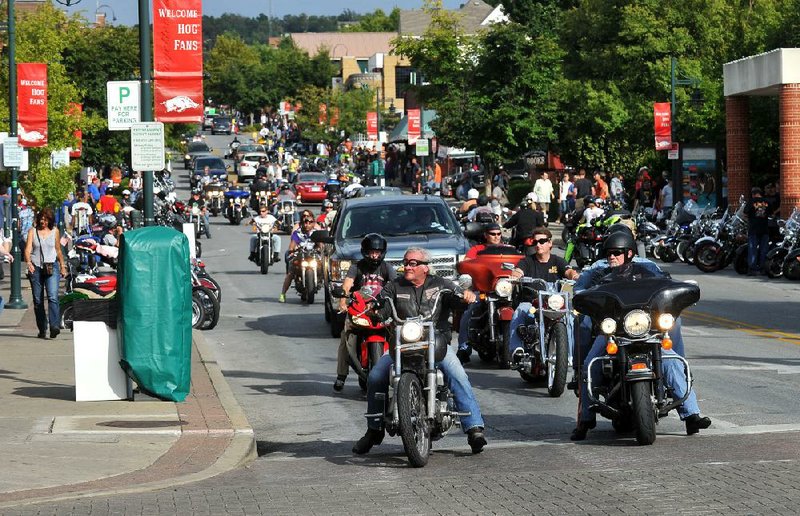 NWA Media/MICHAEL WOODS --09/19/2013--   Bikers cruse up Dickson Street in Fayetteville Thursday afternoon during the second day of the 14th annual Bikes Blues and BBQ in Fayetteville.  The annual bike rally runs through Saturday.
