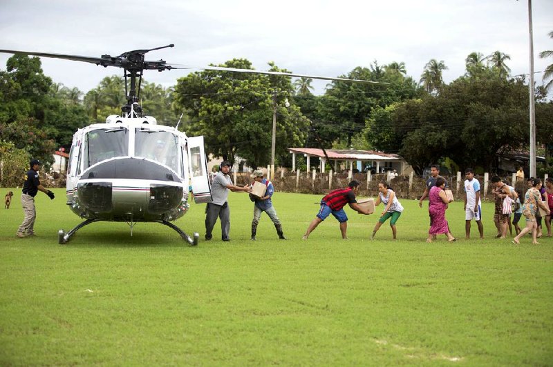 Villagers unload aid from a helicopter from Mexico’s attorney general’s office in San Jeronimo, Mexico, on Friday after their community was ravaged by the rains and floods caused of Tropical Storm Manuel. 