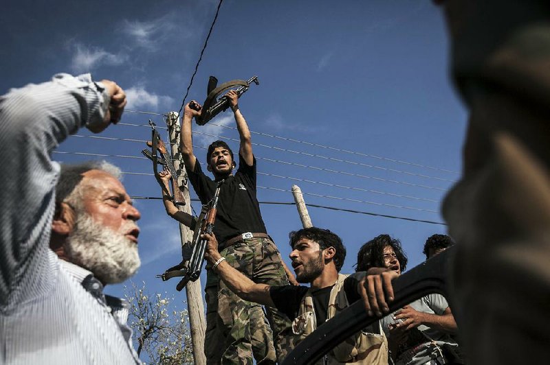 Syrian rebel fighters celebrate Thursday after a battle in Idlib province. Syria’s main Western-backed opposition group issued a warning Friday about the expanding influence of al-Qaida-backed militants. 