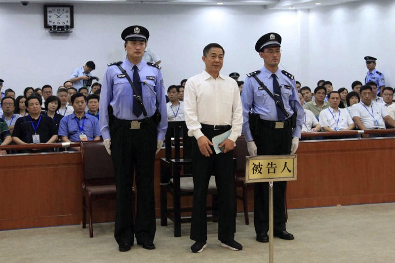 In this photo released by the Jinan Intermediate People's Court, Bo Xilai, center, who was tried last month on charges of taking bribes, embezzlement and abuse of power, stands inside the court in Jinan, in eastern China's Shandong province, Sunday, Sept. 22, 2013. The Chinese court convicted the fallen politician of corruption and sentenced him to life in prison. (AP Photo/Jinan Intermediate People's Court)