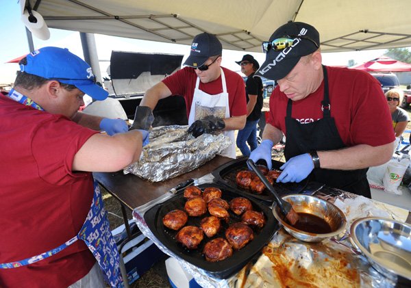 Ed Boles, right, Erik Maxwell and Richard Murphy, all of Beer Butt Que in Lee's Summit, Mo., work to prepare their division entry in the barbecue contest Saturday, Sept. 21, 2013, during the 14th annual Bikes, Blues & BBQ motorcycle rally at the Washington County Fairgrounds in Fayetteville.