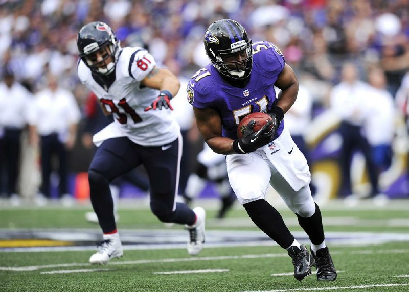 Baltimore Ravens inside linebacker Daryl Smith, right, intercepts a pass attempt in front of Houston Texans tight end Owen Daniels in the first half of an NFL football game, Sunday, Sept. 22, 2013, in Baltimore. Smith returned the interception for a touchdown. (AP Photo/Nick Wass)