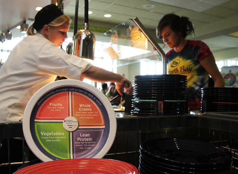 In this photo taken Wednesday Sept. 11, 2013 a new designed plate is propped up at the dining hall at the University of New Hampshire in Durham, N.H. The plates are printed with dietary guidelines in hopes students will choose healthier foods.(AP Photo/Jim Cole)