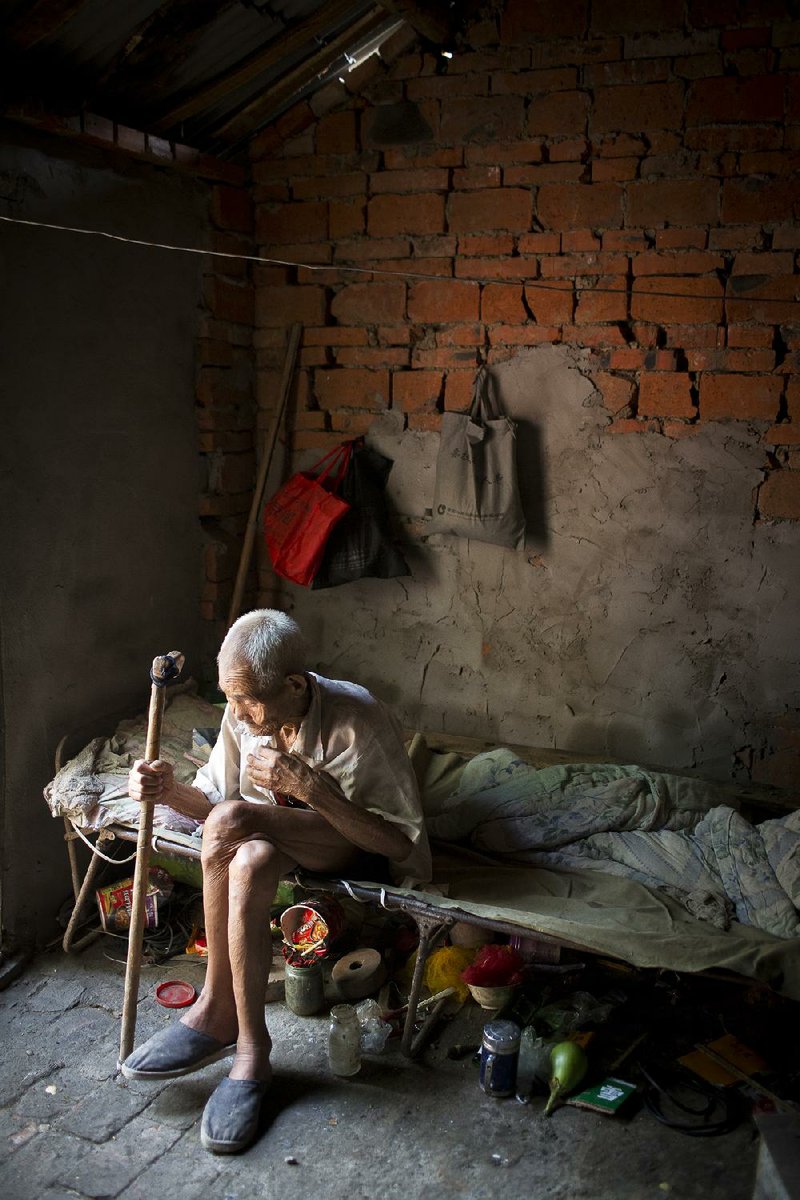 In Gonggou, China, 87-year-old Dou Shengli (shown) lives with his 85-year-old wife He Xiuying in a typical one-room house. Although they have two sons still living nearby, and three daughters, the couple gets little help with their living expenses and medical costs. Illustrates CHINA-ELDERLY (category i), by Simon Denyer © 2013, The Washington Post. Moved Wednesday, Sept. 18, 2013. (MUST CREDIT: Photo for The Washington Post by Qilai Shen)