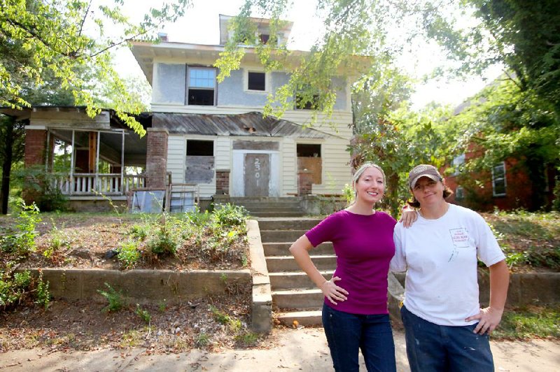 Jennifer Carman (left) stands with Donna Thomas outside the house in the 2300 block of South Summit in Little Rock that the women are restoring with the help of historic-preservation tax credits that Carman called a “godsend.” 