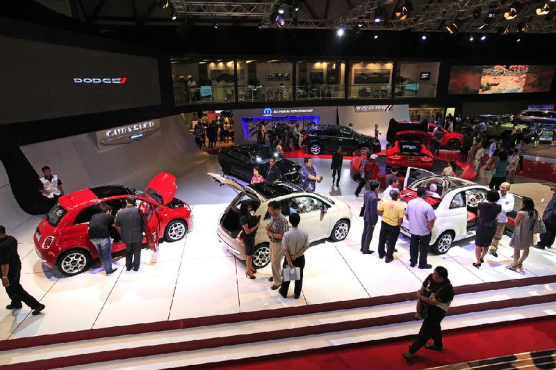 Attendees look at the Chrysler Group LLC display at the 21st Indonesia International Motor Show in Jakarta on Thursday. Fiat, the majority owner of Chrysler Group, is threatening to end assistance to the company if the United Auto Workers retiree trust succeeds in selling its stake in an initial public offering. 