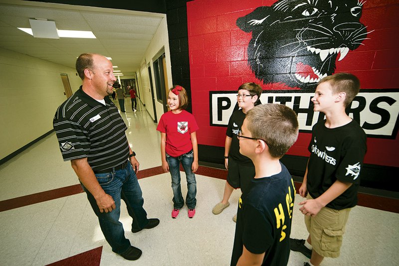 Clockwise from the left, Damon Bivins chats with Joise Jones, Drake Cohea, Mason Bivins and Ethan Carter at Cabot Middle School North. Bivins is one of the volunteers involved with the Cabot School District’s Hallway Heroes program.