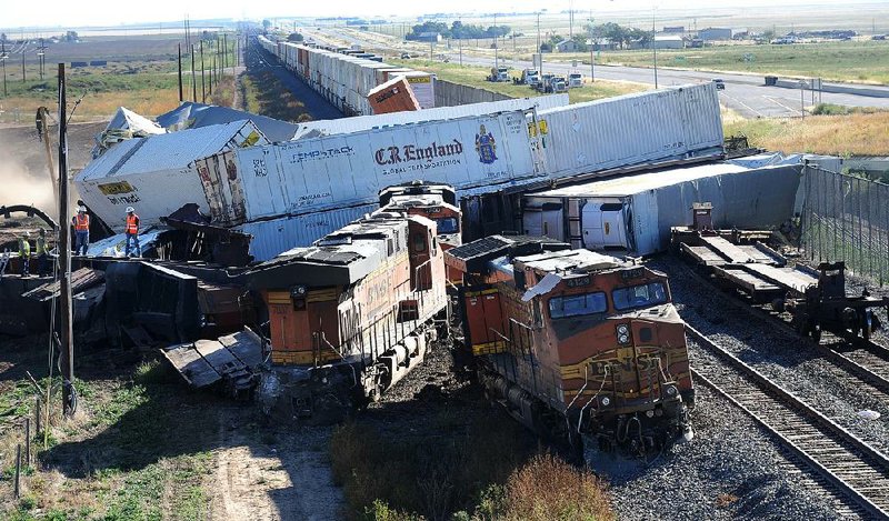 Cars from three freight trains sit jumbled Wednesday near Amarillo, Texas, after a wreck near dawn that derailed up to 30 cars and injured four crewmen. An eastbound BNSF Railway train rear-ended a stopped train, then a westbound train slammed into the first two trains.