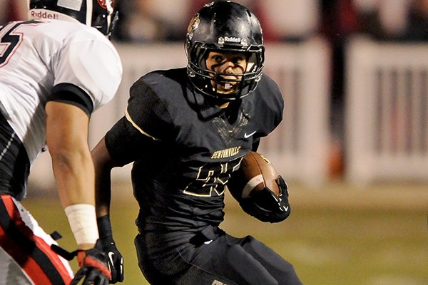 Bentonville running back Dylan Smith locks his sight on a Euless (Texas) Trinity defender while carrying the ball during the football game on Friday September 20, 2013 in Tiger Stadium in Bentonville.