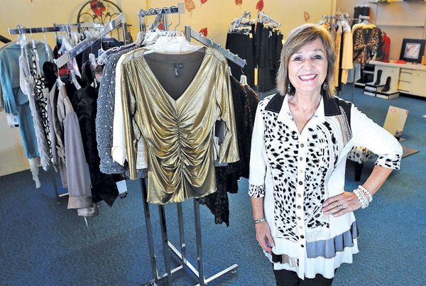 Stevette Mayes, owner, stands on the second story of her clothing shop Wednesday at Stevette’s Fine Fashions at 215 W. Walnut St. in Rogers. Mayes will be closing her shop after 16 years when she retires. 