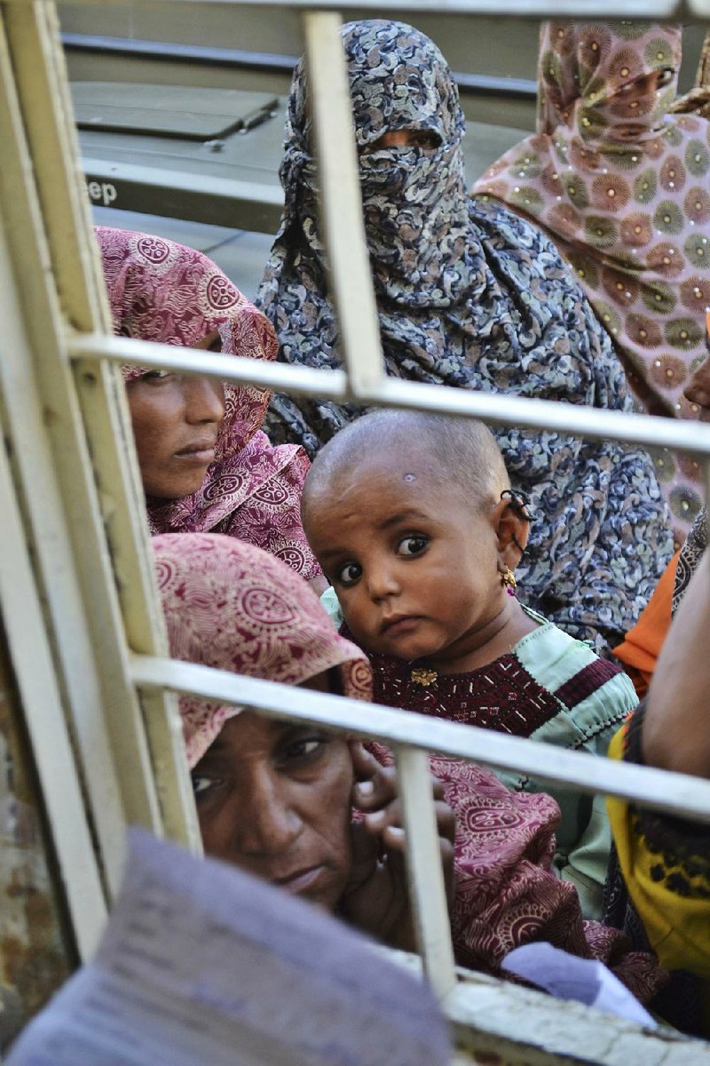 Pakistani women gather by the window of a local clinic waiting to receive medical relief, following an earthquake in Labach, the remote district of Awaran in Baluchistan province, Pakistan, Thursday, Sept. 26, 2013. Two days after the tremor struck, rescuers were still struggling to help survivors. The death toll from the quake reached in hundreds on Thursday, with more than 500 people injured. (AP Photo/Arshad Butt)