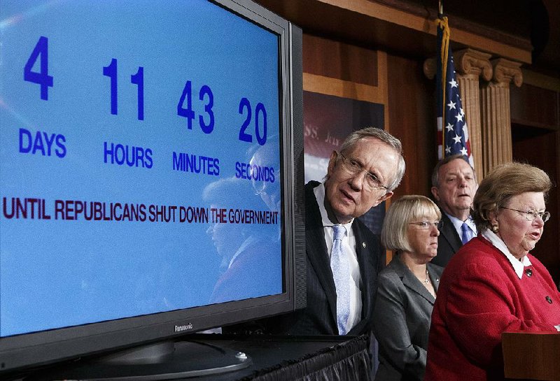 With four days to go before the federal government is due to run out of money, Senate Majority Leader Harry Reid, D-Nev., center, looks at a countdown clock as Senate Democratic leaders blame conservative Republicans for holding up a stopgap spending bill to keep the government running, during a news conference at the Capitol in Washington, Thursday, Sept. 26, 2013. From left to right are Sen. Harry Reid, D-Nev., Sen. Patty Murray, D-Wash., chair of the Budget Committee, Senate Majority Whip Dick Durbin, D-Ill., and Sen. Barbara Mikulski, D-Md., chair of the Appropriations Committee. Senate passage of the spending bill — stripped of the "Obamacare" provision — was expected no later than Saturday.   (AP Photo/J. Scott Applewhite)