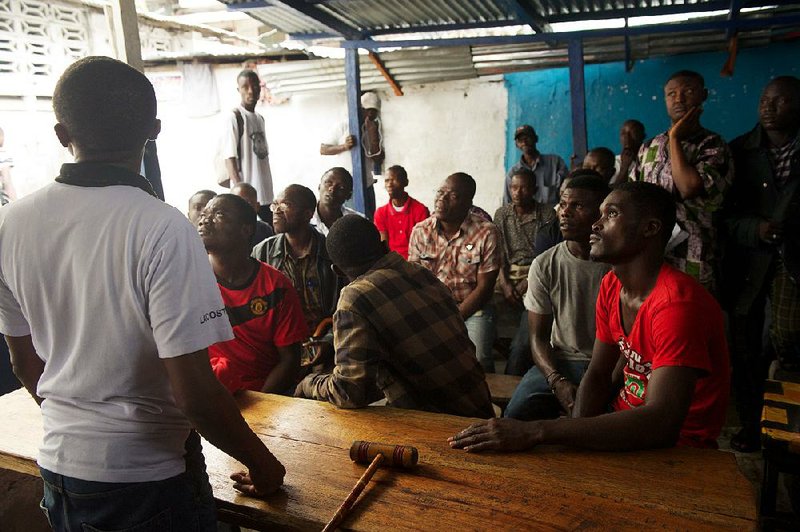 Men gather at a popular downtown tea shop known as a hotspot for political debate, to watch the announcement of a verdict in the appeal of former Liberian President Charles Taylor, in downtown Monrovia, Liberia, Thursday, Sept. 26, 2013. An international war crimes court upheld the conviction and 50-year sentence of the former president for aiding rebels in neighboring Sierra Leone, ruling Thursday that his financial, material and tactical support fueled horrendous crimes against civilians. (AP Photo/Mark Darrough)