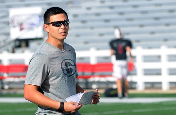 Matt Clinkscales, a former Springdale football player, helps supervise practice with receivers Tuesday, Sept. 24, 2013, at Jarrell Williams Bulldog Stadium in Springdale. Clinkscales graduated in 2005 and is now a volunteer coach for the Bulldogs.