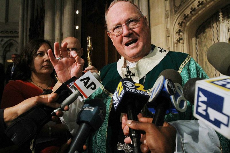 Cardinal Timothy Dolan, right, speaks to the media after Mass, Sunday, Sept. 22, 2013, at St. Patrick's Cathedral in New York. Pope Francis' said Sept. 19, that pastors should focus less on divisive social issues and should emphasize compassion over condemnation. Dolan told reporters that Francis, "speaks like Jesus" and is a "breath of fresh air.