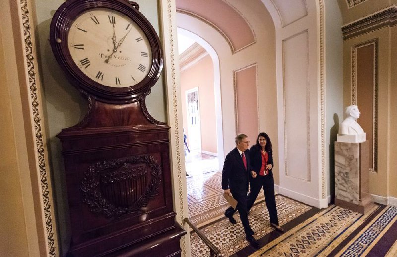 With time running out, Senate Minority Leader Mitch McConnell walks past the Ohio Clock to the House chamber Friday for the vote on a bill to fund the government, but stripped of language that defunds the health-care law. 
