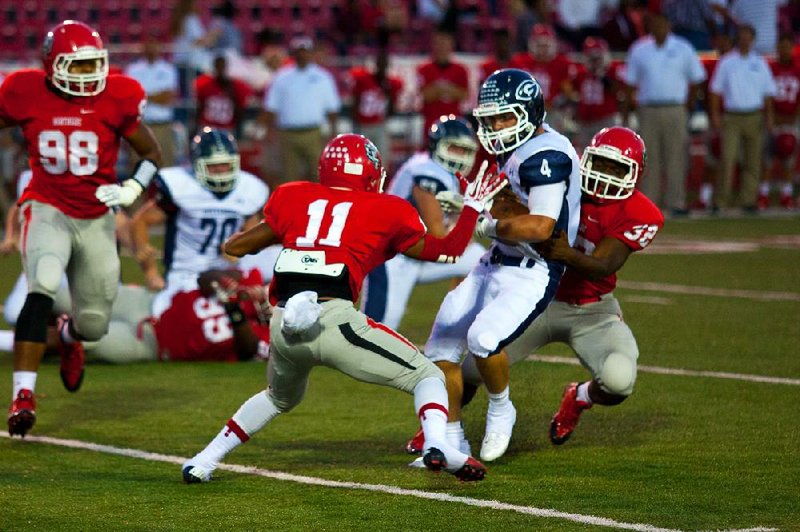 Greenwood’s Hoyt Smith (4) is pulled down by Fort Smith Northside’s Dtravius Jackson (11) and Daiquon Jackson during Friday night’s game at Mayo-Thompson Field in Fort Smith. 