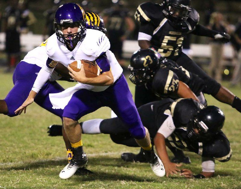 Ashdown quarterback Jake Alexander (left) scrambles away from several Pulaski Robinson defenders Friday night in Little Rock. 