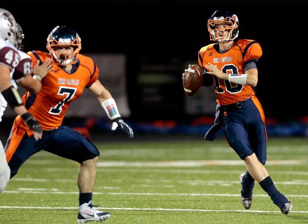 Rogers Heritage senior Josh Qualls rolls out looking for a receiver during the first half against Siloam Springs on Friday, Sept. 27, 2013, at Gates Stadium in Rogers.