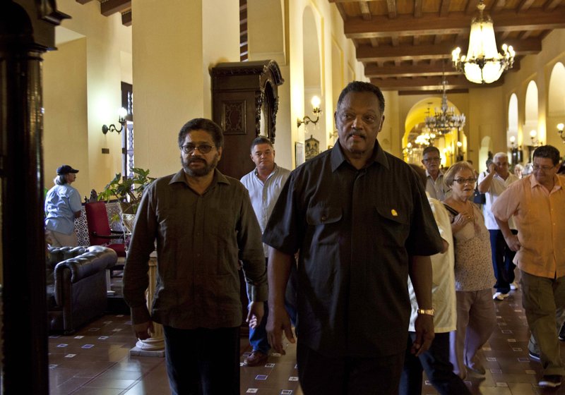 Rev. Jesse Jackson, center, and Ivan Marquez, left, chief negotiator for the Revolutionary Armed Forces of Colombia, or FARC, walk after a meeting at the Hotel Nacional in Havana, Cuba, Sunday, Sept. 29, 2013. Jackson says he intends to press forward in a bid to mediate the release of a U.S. Army veteran taken captive by Colombian rebels three months ago. (AP Photo/Ramon Espinosa)