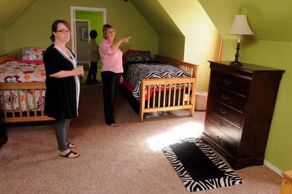 Elena Terrell, left, and Tammy Fowler, both employees with Youth Bridge, look at a room inside the Bell House during a tour of the refurbished home at the Youth Bridge site in Fayetteville. Bell House is part of the Transitional Living Program. 
