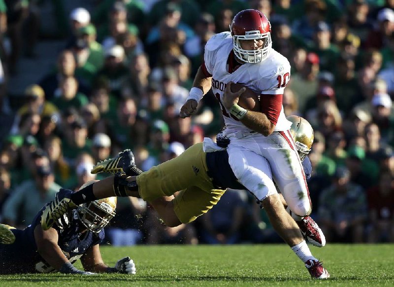 Oklahoma's Blake Bell (10) runs out of the tackle of Notre Dame 's Dan Fox during the second half of an NCAA college football game on Saturday, Sept. 28, 2013, in South Bend, Ind. Oklahoma defeated Notre Dame 35-21. (AP Photo/Darron Cummings)