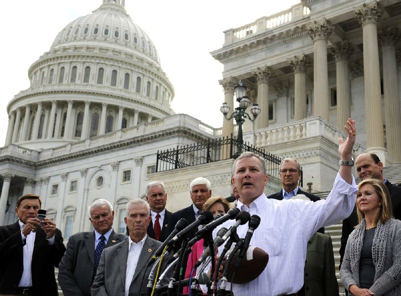 Rep. Tim Griffin, R-Ar., right, joins other Republican House Members as they call on Senate Democrats to "come back to work" on the Senate Steps of the U.S. Capitol Sunday, Sept. 29, 2013 as the United States braces for a partial government shutdown Tuesday after the White House and congressional Democrats declared they would reject a bill approved by the Republican-led House to delay implementing President Barack Obama's health care reform. (AP Photo/Cliff Owen)