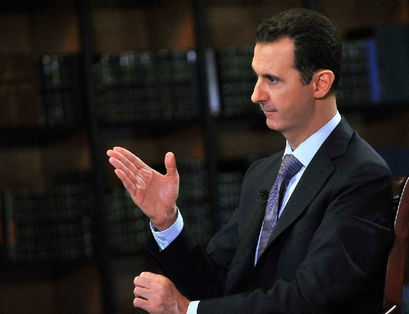 In this photo, which AP obtained from Syrian official news agency SANA, has been authenticated based on its contents and other AP reporting, President Bashar Assad gestures as he speaks during an interview with Italy's RAI News 24 TV, at the presidential palace in Damascus, Syria, Sunday, Sept. 29, 2013. Assad says his government will abide by last week's U.N. resolution calling for the country's chemical weapons program to be dismantled and destroyed. (AP Photo/SANA)