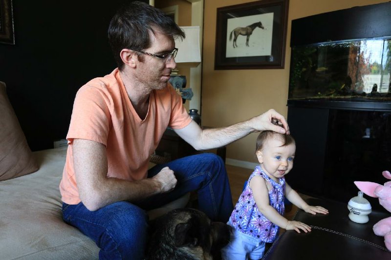 Eric Olson watches over his daughter, Linnea, at their home in North Little Rock. The toughest part of his wife Samantha’s death, he said, “is completely accepting the reality of it,” adding: “There are these moments of like, man, she’s not coming back.”


