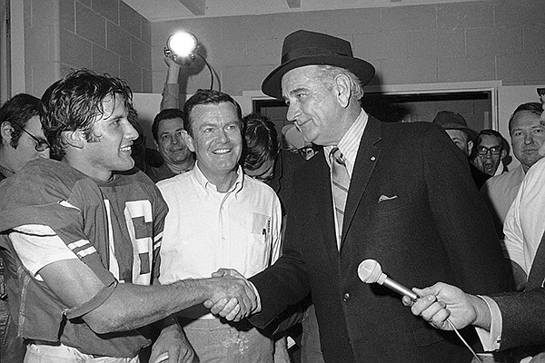 This Jan. 1, 1970 file photo shows former President Lyndon B. Johnson congratulating University of Texas quarterback James Street and coach Darrell Royal, center, in the dressing room after the Longhorns defeated Notre Dame in the Cotton Bowl in Dallas. (AP Photo/File)