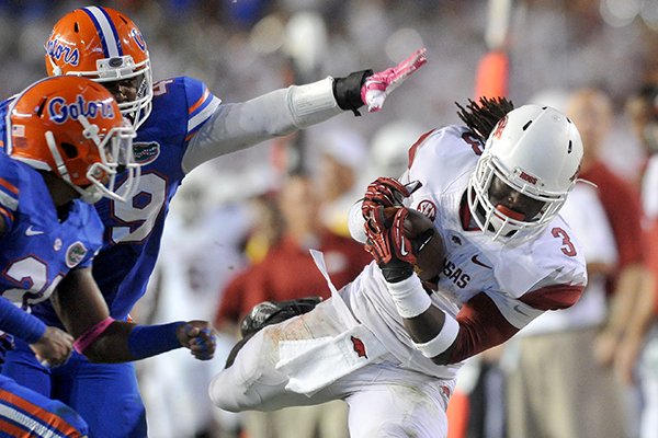 Arkansas Alex Collins pulls in a pass past Florida defender Darin Kitchens during the 3rd quarter of Saturday night's game at Ben Hill Griffin Stadium in Gainesville, Florida.