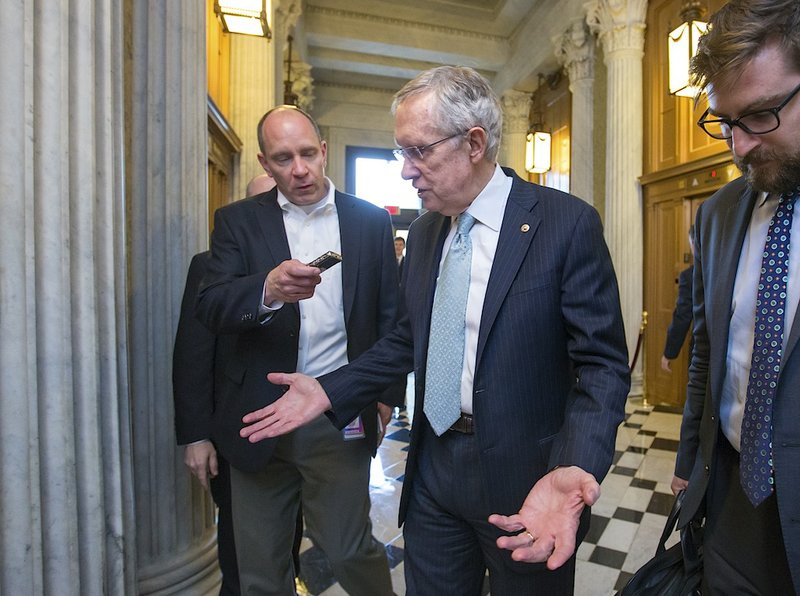 With the government shutdown still unresolved, Senate Majority Leader Harry Reid, D-Nev., speaks briefly with a reporter as he leaves the chamber at the end the day, Saturday, Oct. 5, 2013, at the Capitol in Washington. There has been no sign of progress toward ending an impasse that has idled 800,000 federal workers and curbed services around the country.