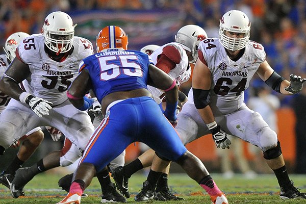 Arkansas linemen Denver Kirkland and Travis Swanson look to block Florida defender Darious Cummings during Saturday night's game at Ben Hill Griffin Stadium in Gainesville, Fla. 