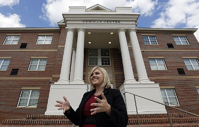 In this Oct. 1, 2013, photo, Newman Center community director Kelsey Burgans stands outside the faith-based dormitory on the campus of Troy University in Troy, Ala. Tucked in rural southeast Alabama, Troy University has opened something that‚Äôs a rarity for a public college in the United States: A faith-based dorm community where daily Bible studies are common and beer drinking is strictly forbidden.