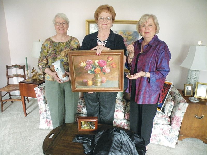 Conway Symphony Orchestra Guild members, from the left, Patsy Desaulniers, Mary Mosley and Beverley Freiley display some of the items that will be up for bid Thursday at All That Jazz. The fundraising event will be held at the Southwestern Energy Co. headquarters at The Village at Hendrix. 