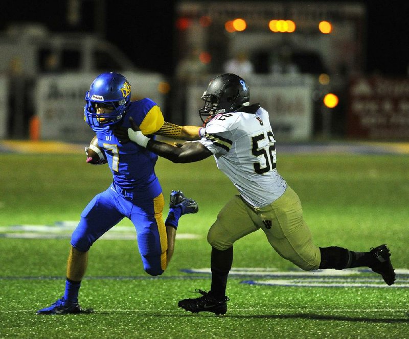 North Little Rock wide receiver Clayton Smith (left) tries to elude Jonesboro linebacker Sammie Beason during Friday night’s game in North Little Rock. Charging Wildcats quarterback Heath Land completed 21 of 31 passes for 303 yards and 3 touchdowns. 