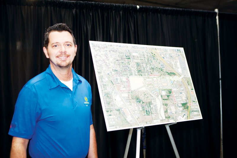 Brad Lacy, president and CEO of the Conway Area Chamber of Commerce and the Conway Development Corp., stands with the site plan unveiled this month for Central Landing, a mixed-use development that will be built on the 151-acre current airport property once a new airport opens. He said the first phase of retail should open in November 2017. The Dan Nabholz Award will be presented to Lacy by the Faulkner County Leadership Institute at its Nov. 11 banquet in Conway.