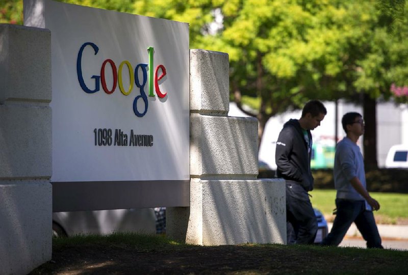 Pedestrians walk past Google Inc. signage displayed in front of the company's headquarters in Mountain View, California, U.S., on Friday, Sept. 27, 2013. Google is celebrating its 15th anniversary as the company reaches $290 billion market value. Photographer: David Paul Morris/Bloomberg